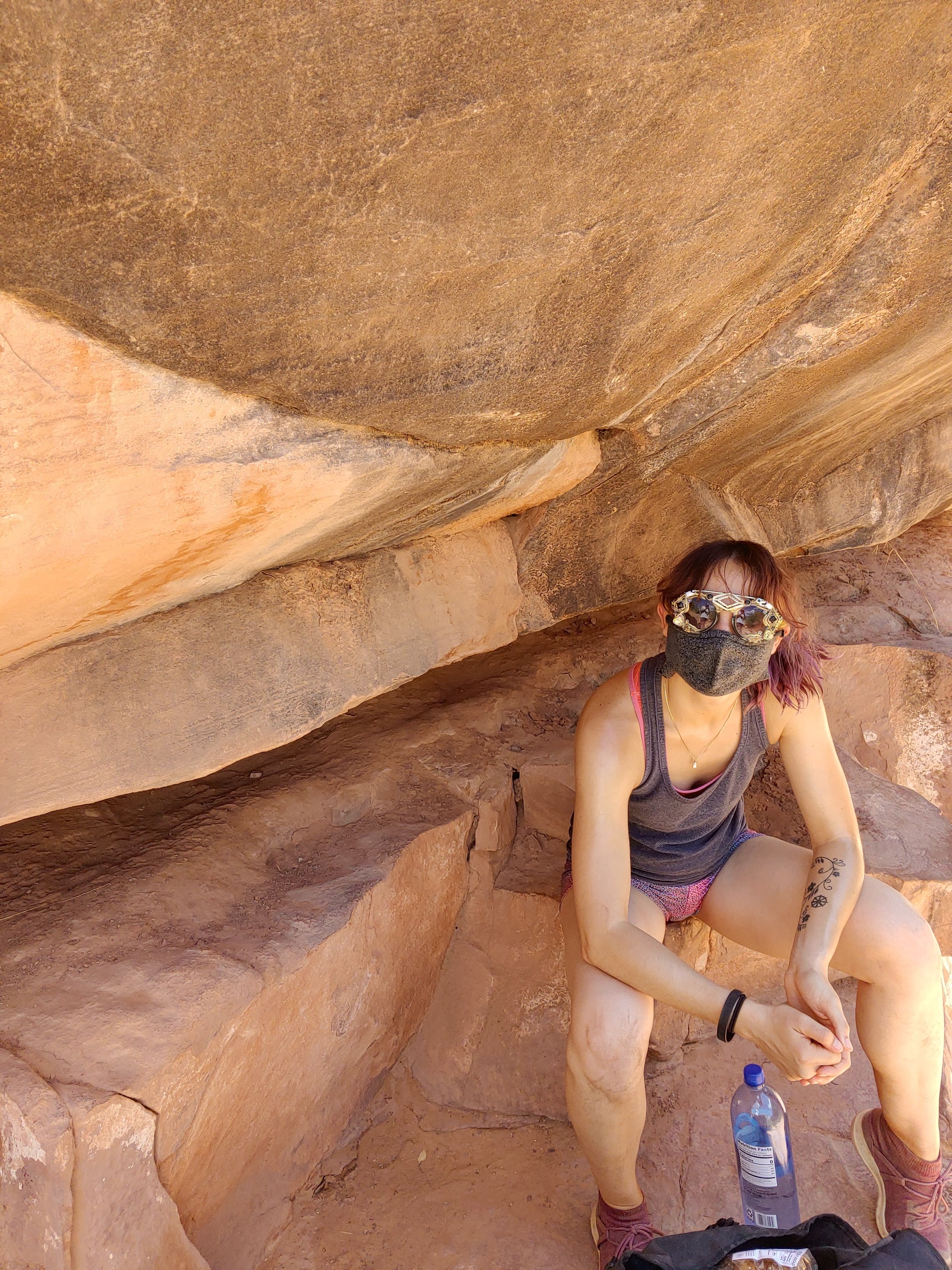 Kristy resting beneath a sandstone rock overhang