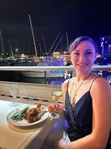 Kristy dining at a marina at night