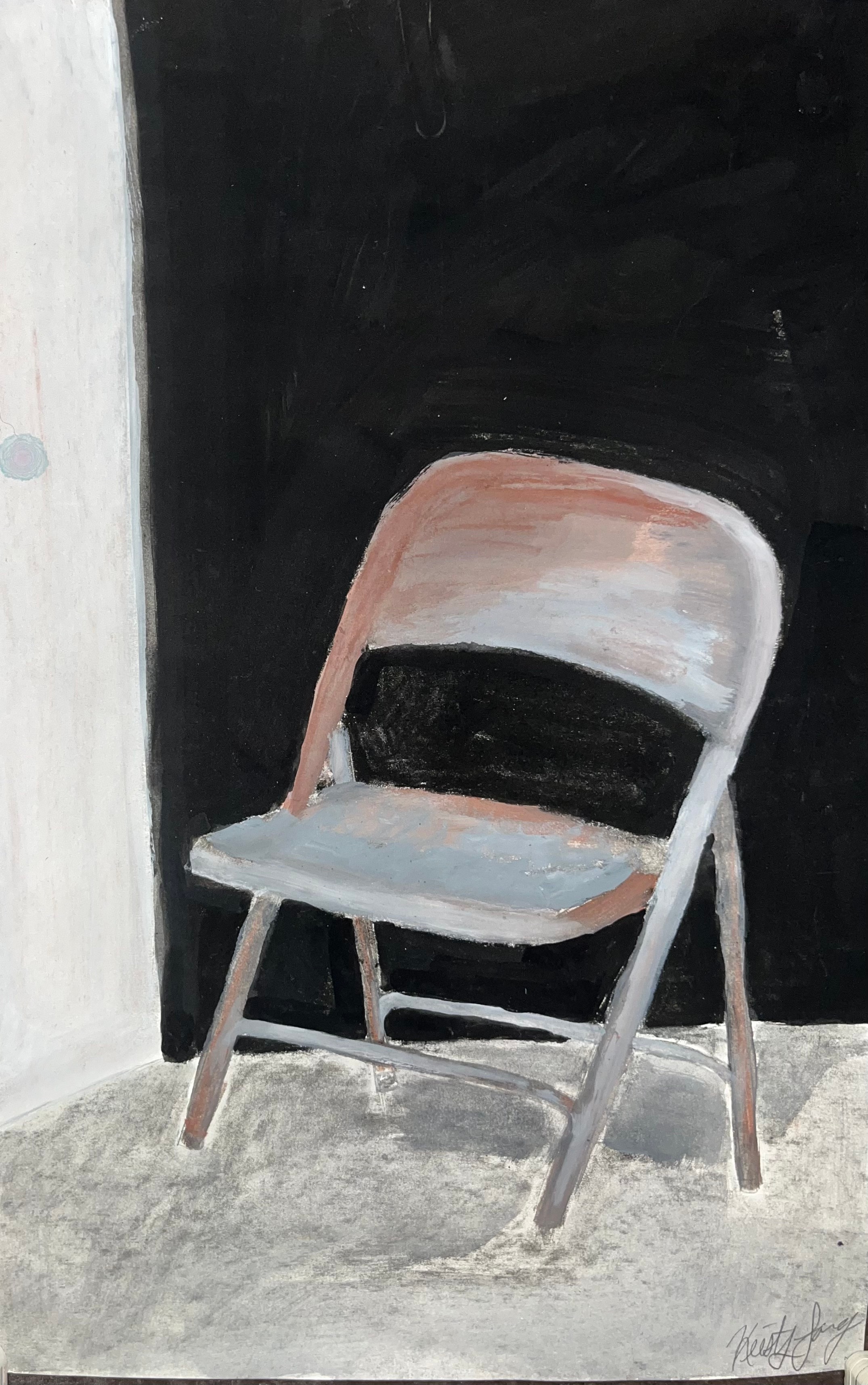 Folding chair against a black wall
